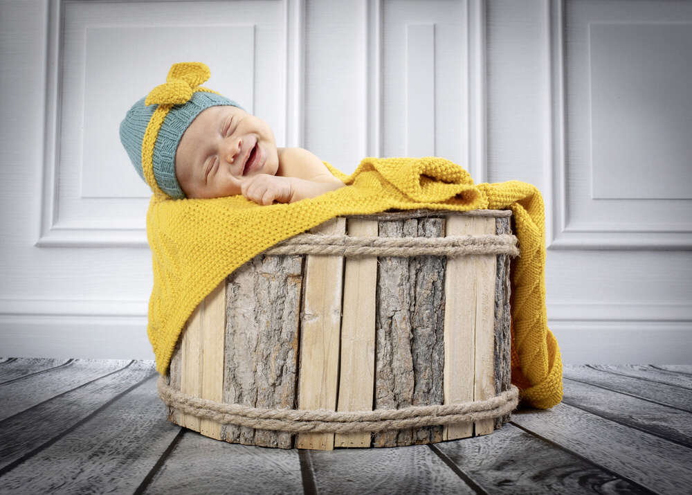 Ein lachendes Baby in  einer Kiste (Fotostudio Wedermann)