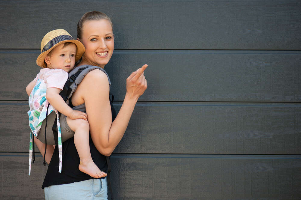 Mutter mit Kind in Tragehilfe (Kessler Fotografie)