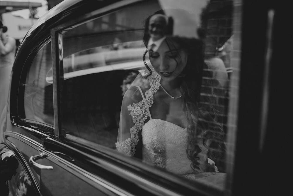 Braut wartet im Auto und Vater spiegelt sich im Fenster der Limousine (Werner Philipps)