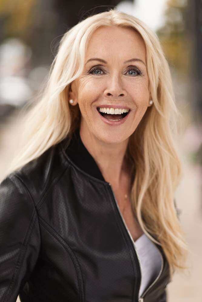 Lachende Frau in Lederjacke, festgehalten in einem lebendigen Porträtfoto im Freien (Headshot Master)