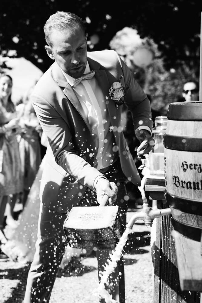 Bräutigam schlägt das Bierfaß an in der Stögeralm am Schliersee (Jennifer Hartmann | Photography & Artist)