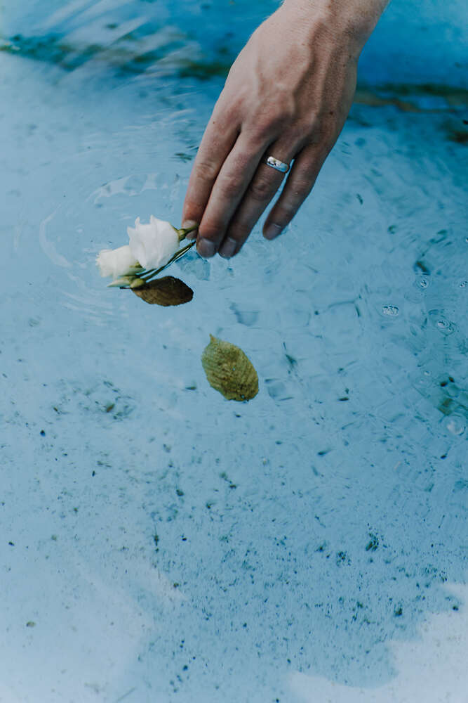 Braut fischt eine verlorene Blume aus dem Brautstrauß aus den Brunnen (Jennifer Hartmann | Photography & Artist)
