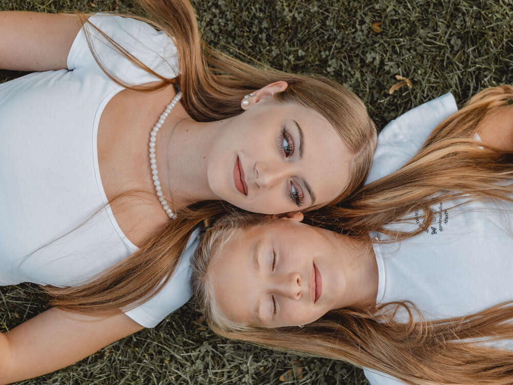 Portrait zwei Schwestern liegend auf Wiese  (Axel Jahnke | Fotografie)