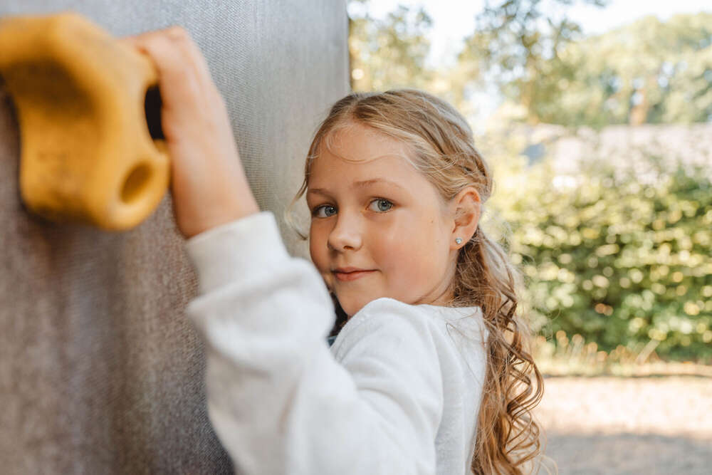 Mädchen klettert an Kletterwand am Fototag im Kindergarten, outdoor  (Axel Jahnke | Fotografie)