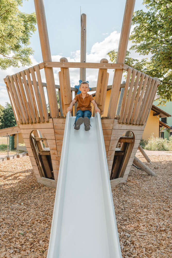 Junge rutscht am Fototag im Kindergarten die Rutsche herunter (Axel Jahnke | Fotografie)