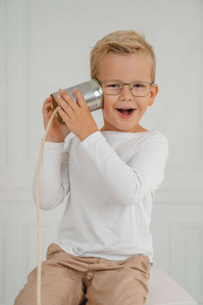 Junge telefoniert mit Büchsentelefon am Fototag im Kindergarten  (Axel Jahnke | Fotografie)