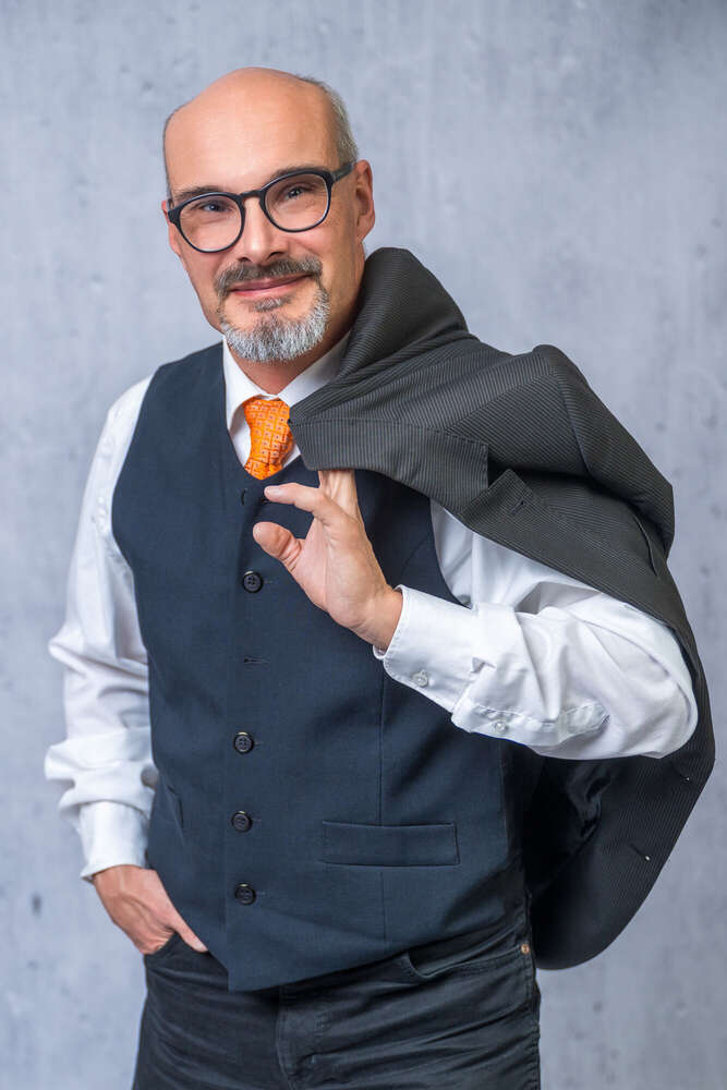 Porträt eines Mann im Anzug, das Jacket locker über Schulter  (Axel Jahnke | Fotografie)