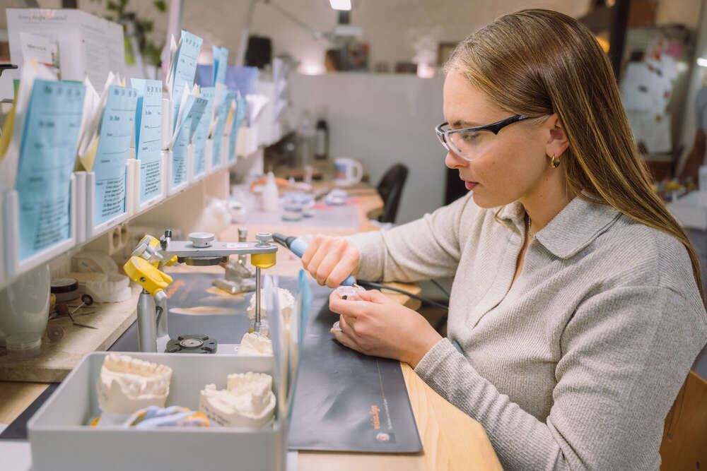 Zahntechnikerin bei der Arbeit, Portrait Aufnahme mit Arbeitsumgebung  (Axel Jahnke | Fotografie)