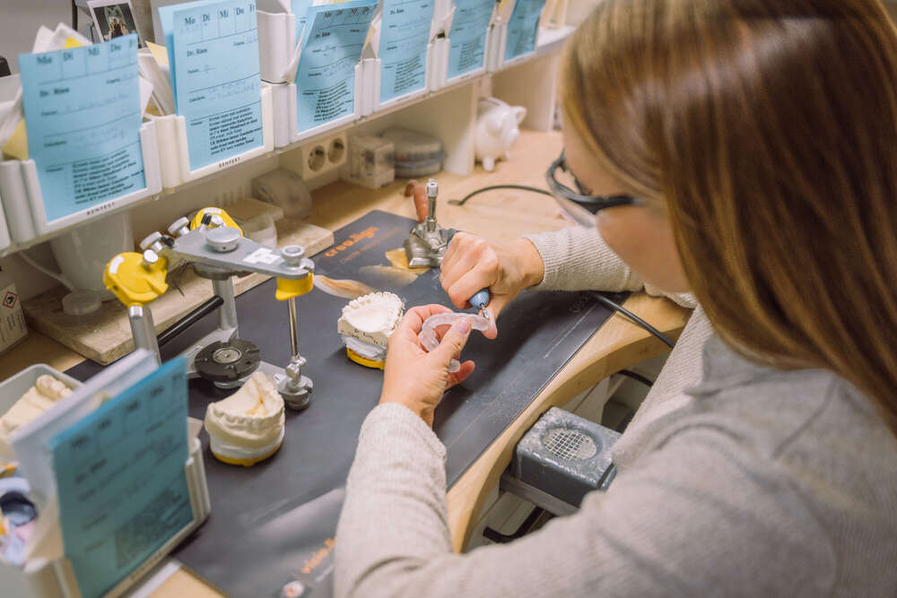 Zahntechnikerin bei der Arbeit, Mitarbeiter Portrait mit Arbeitsumfeld (Axel Jahnke | Fotografie)