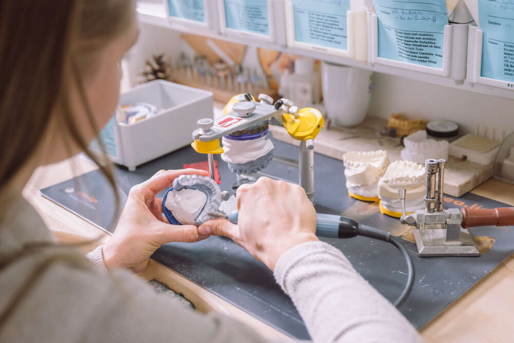 Zahntechnikerin bei der Arbeit mit Arbeitsumfeld (Axel Jahnke | Fotografie)