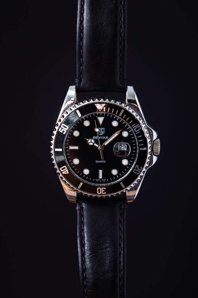 Close-Up Aufnahme einer Armbanduhr vor schwarzem Hintergrund (Leonard Maleika)