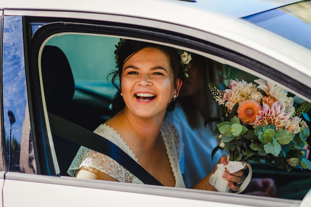 Strahlende Braut im Auto (Grubenglück GmbH)