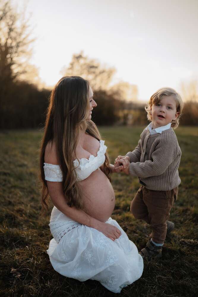 Familienshooting mit Babybauch im Sonnenuntergang
