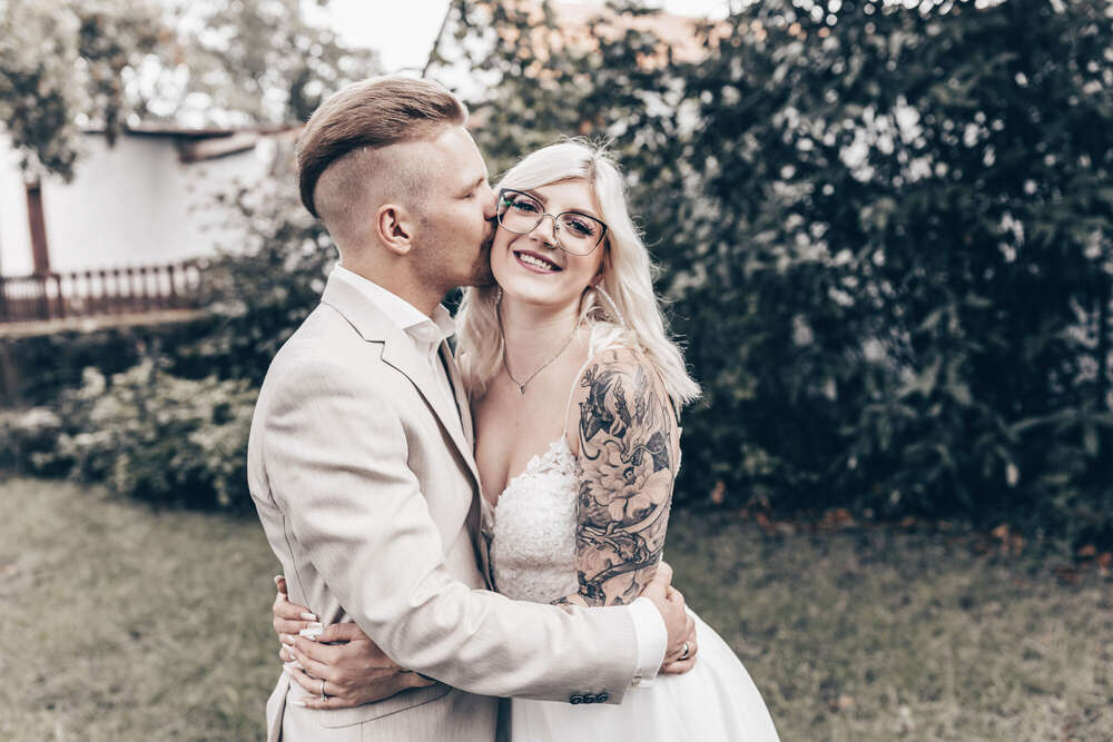 Brautpaar küsst sich im Garten – Hochzeitsporträt voller Emotion (FOKUSNAH)