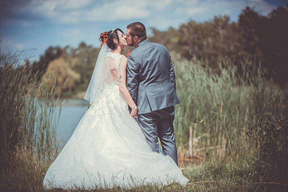 Brautpaar küsst sich am See (FOKUSNAH)