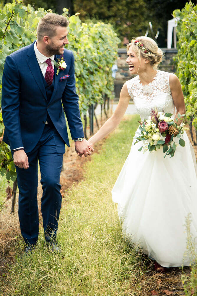 Hochzeitsglück im Weinberg – Brautpaar Hand in Hand (FOKUSNAH)