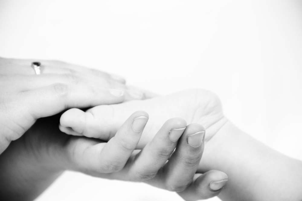 Babyfuß in Mamas Hand (Liebefotografieren)