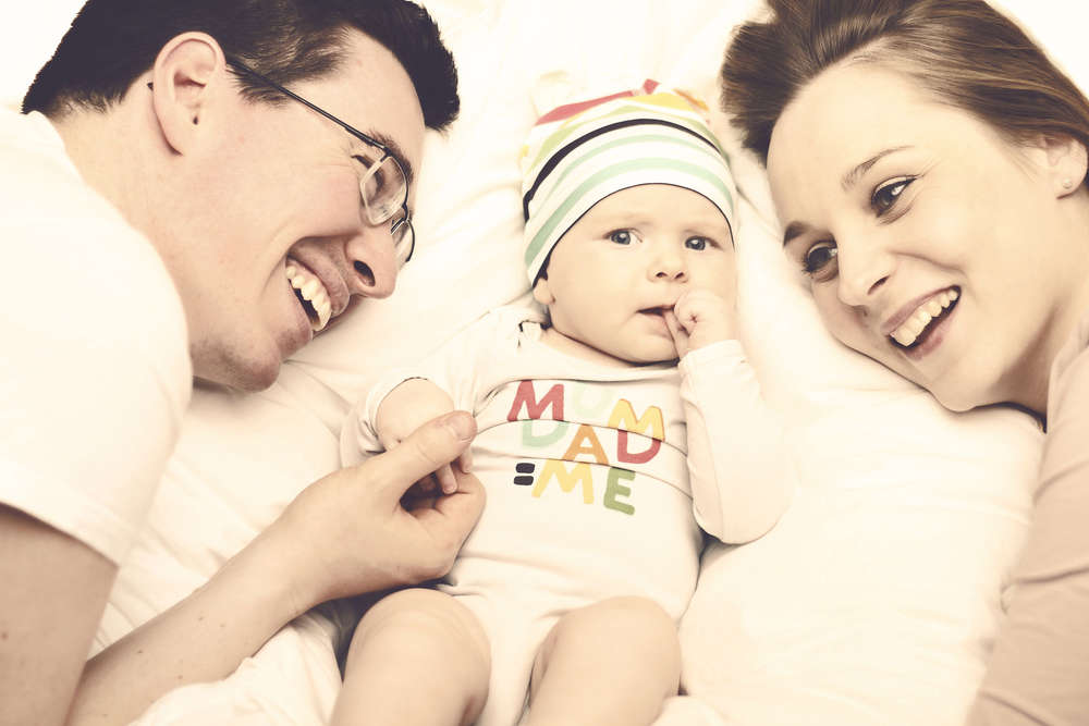 Glückliches Paar mit Baby (Liebefotografieren)