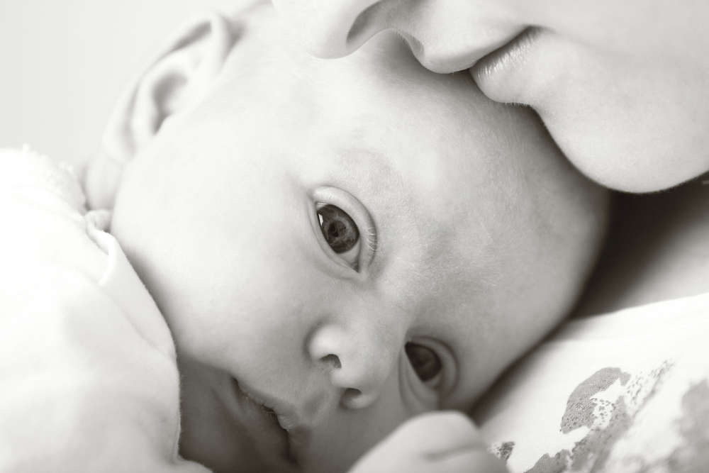 Baby kuschelt mit Mama (Liebefotografieren)